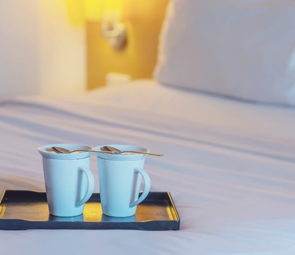 Two cups on a bed in a room