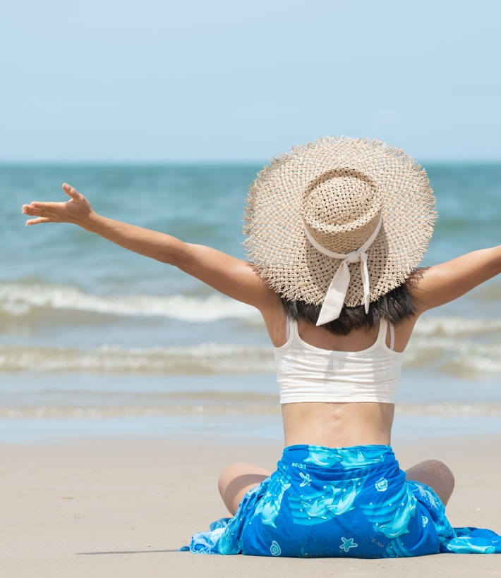 Woman with open arms by the sea